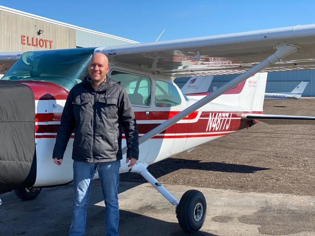 Adam standing by the cessna 172 he flew on solo day.